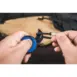 Olight Nightclaw EDC Knife - hands using small blue knife beside a bag strap