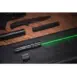 Olight Odin GL-P 1500 Lumen Tactical LED Flashlight - black flashlight emitting green beam on dark case beside detached mount